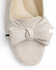 Vista del detalle en flat beige con moño en el empeine de piso y pulsera ajustable para dama 