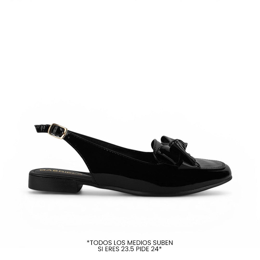 Vista lateral de flat negro para dama de piso con pulsera ajustable y moño en el empeine