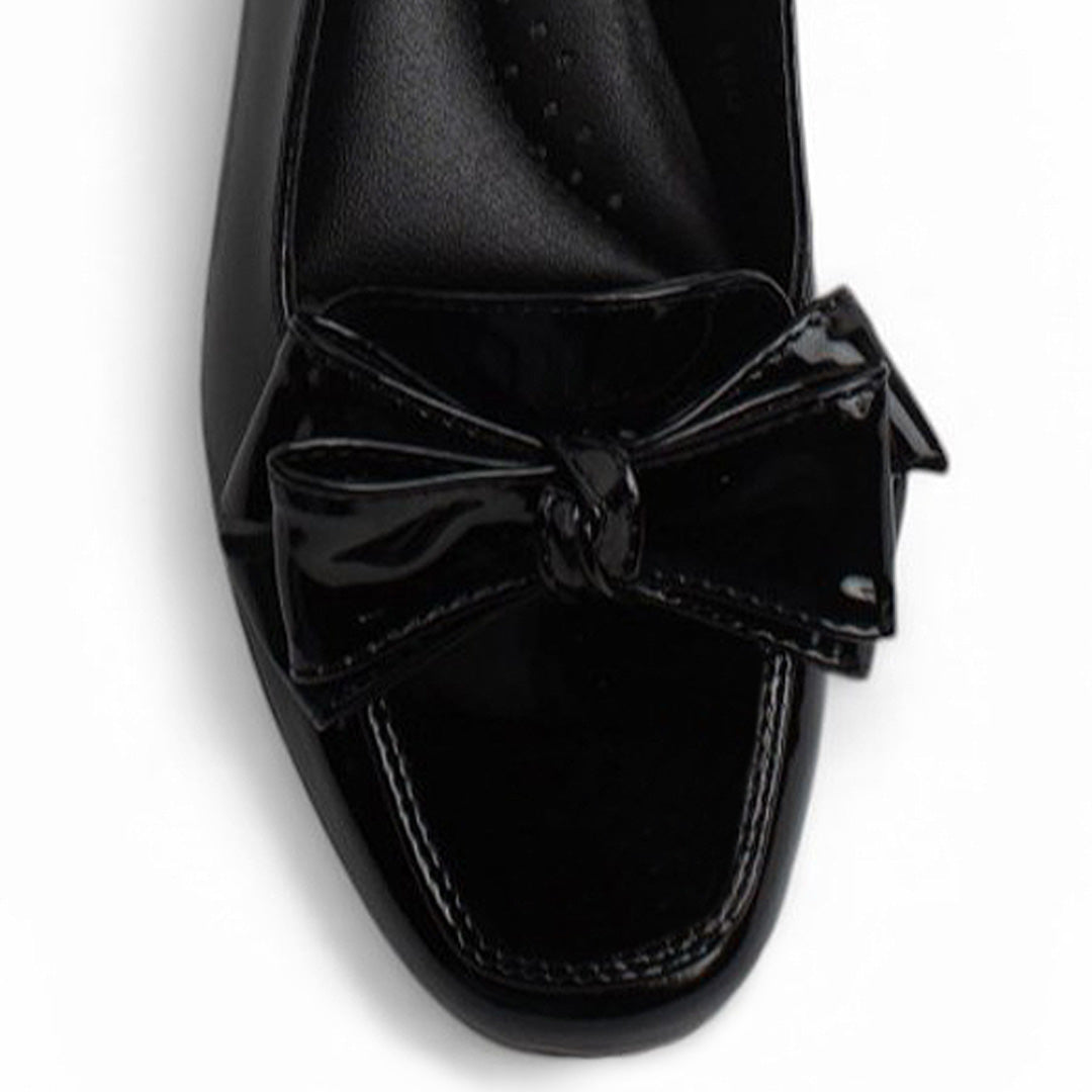 Vista del detalle en flat negro con moño en el empeine de piso y pulsera ajustable para dama 