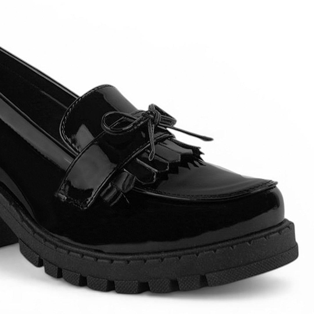 Detalle del material charol de mocasín negro para dama con detalles al frente, plataforma y tacón medio 8 cm