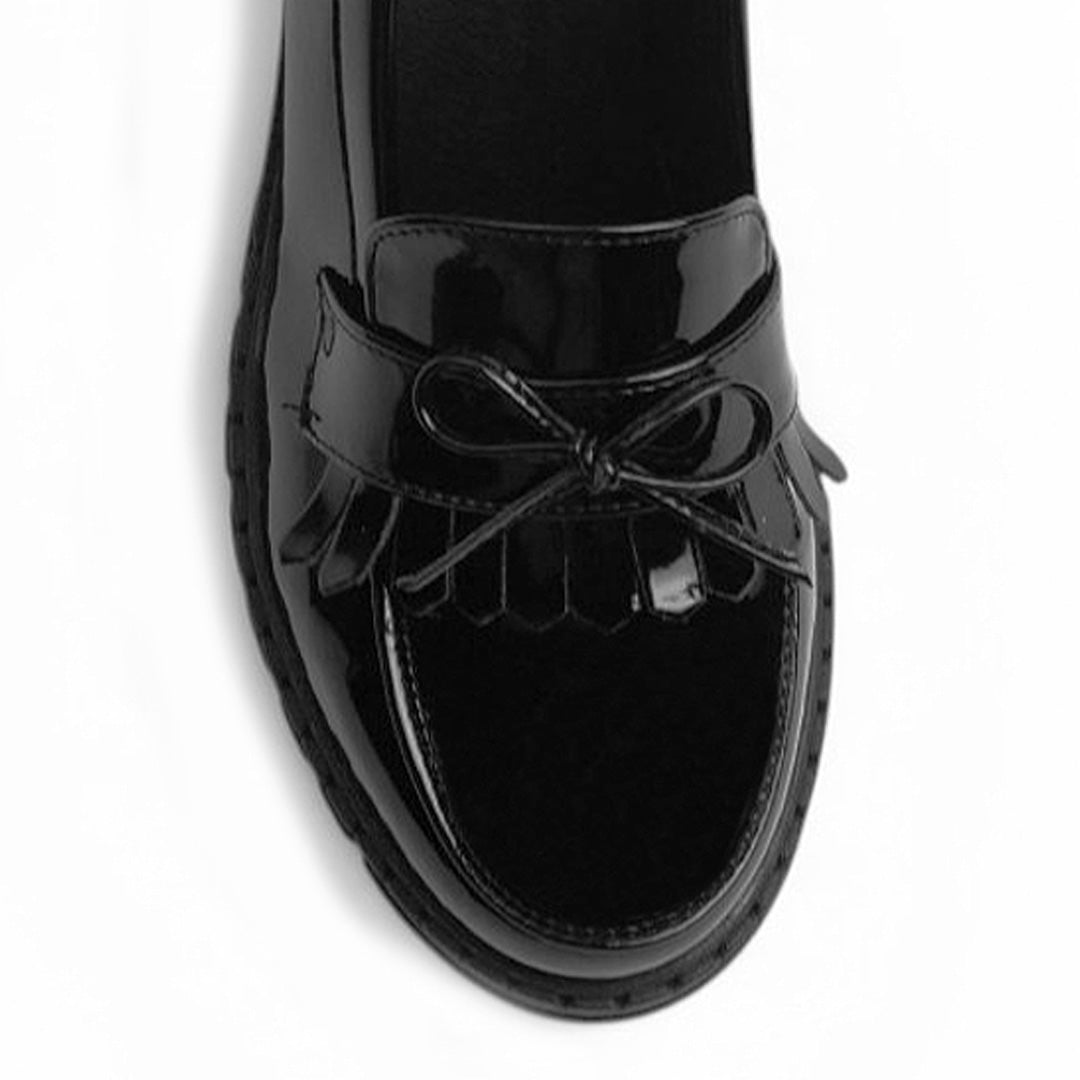 Vista del detalle en moño y flecos del mocasín negro para dama con tacón medio 8 cm 