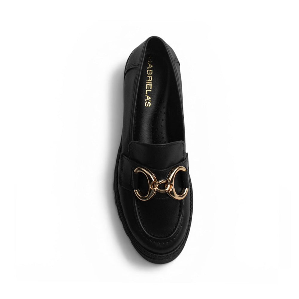 Vista superior de mocasín negro para mujer con herraje de adorno, punta redonda y costuras visibles