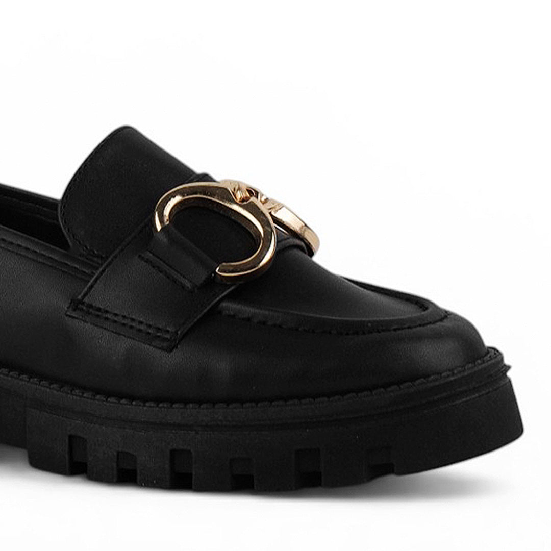 Vista a detalle de punta redonda en mocasín negro para mujer con herraje y costuras visibles