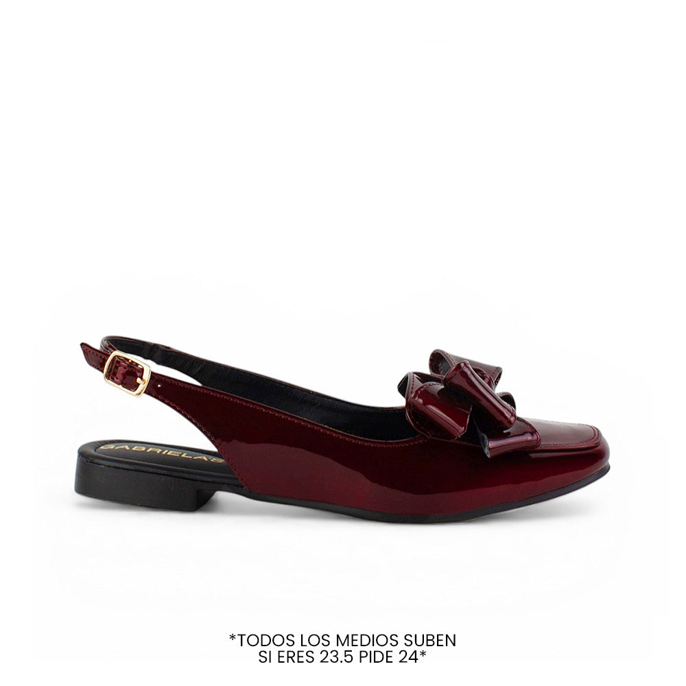 Vista lateral de flat vino para dama de piso con pulsera ajustable y moño en el empeine