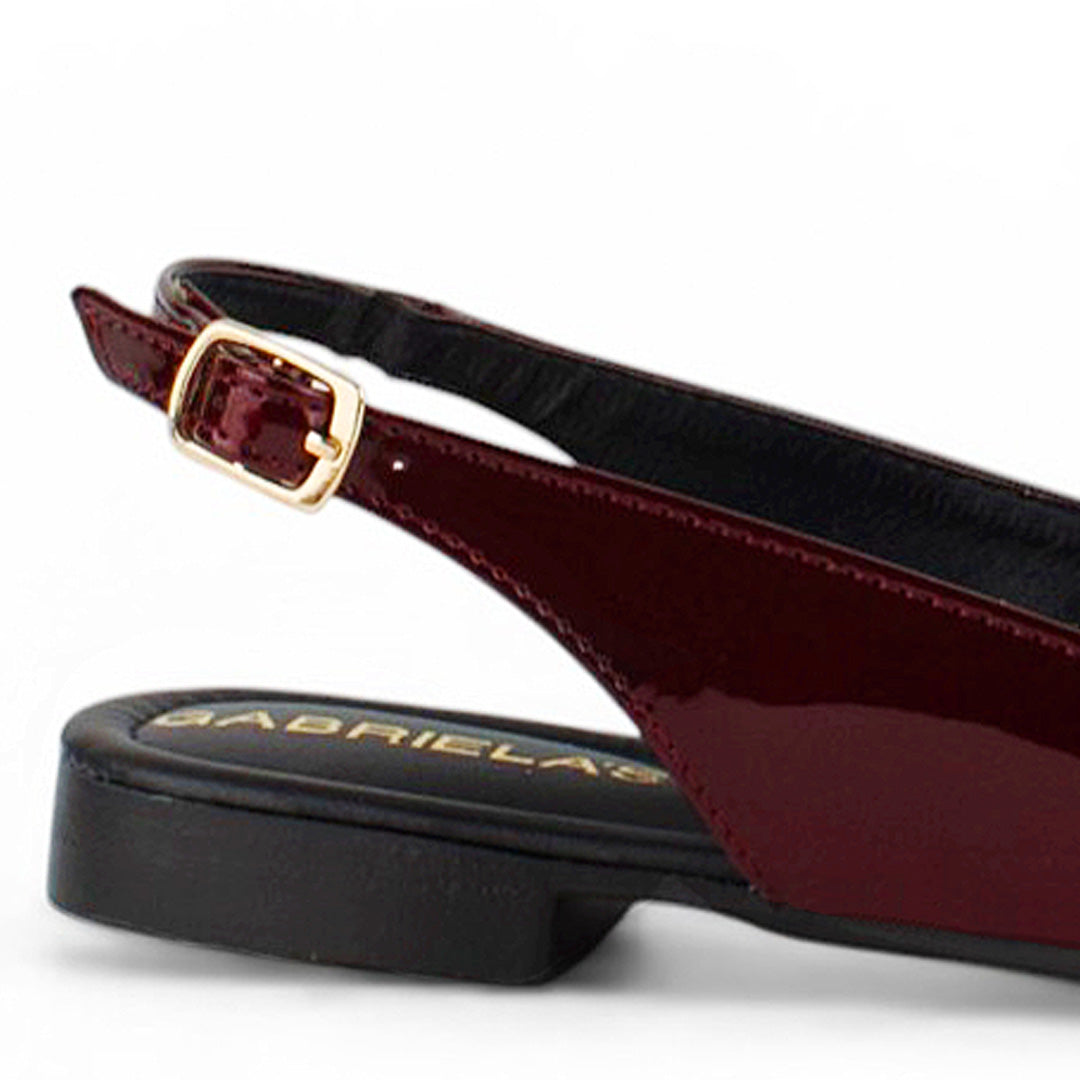 Vista trasera del flat vino para dama con pulsera ajustable de piso y moño en el empeine  