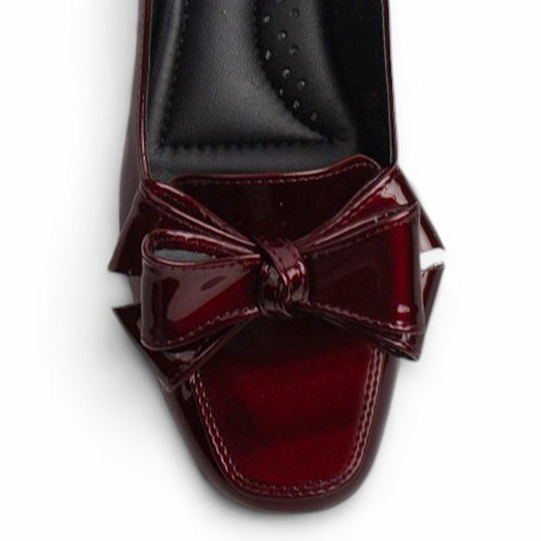 Vista del detalle en flat vino con moño en el empeine de piso y pulsera ajustable para dama 