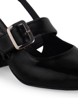 Vista a detalle de zapatilla negra para mujer con punta cerrada, hebilla ajustable y tacón bajo de 5cm