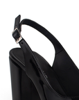 Vista a detalle de correa ajustable en zapatilla negra destalonada para mujer con tacón de 8cm y punta cerrada