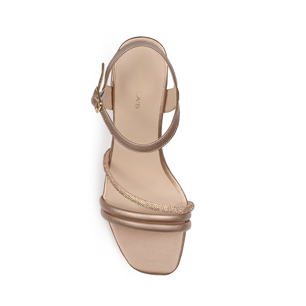 Vista superior de zapatilla oro rosado para mujer con tiras asimétricas con brillos y pulsera ajustable