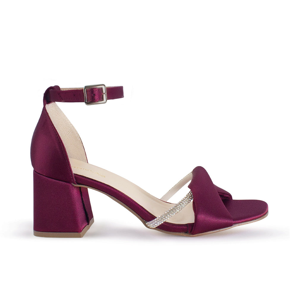 Vista lateral de zapatilla vino para mujer con banda de pedrería pulsera al tobillo y tacón ancho de 7cm