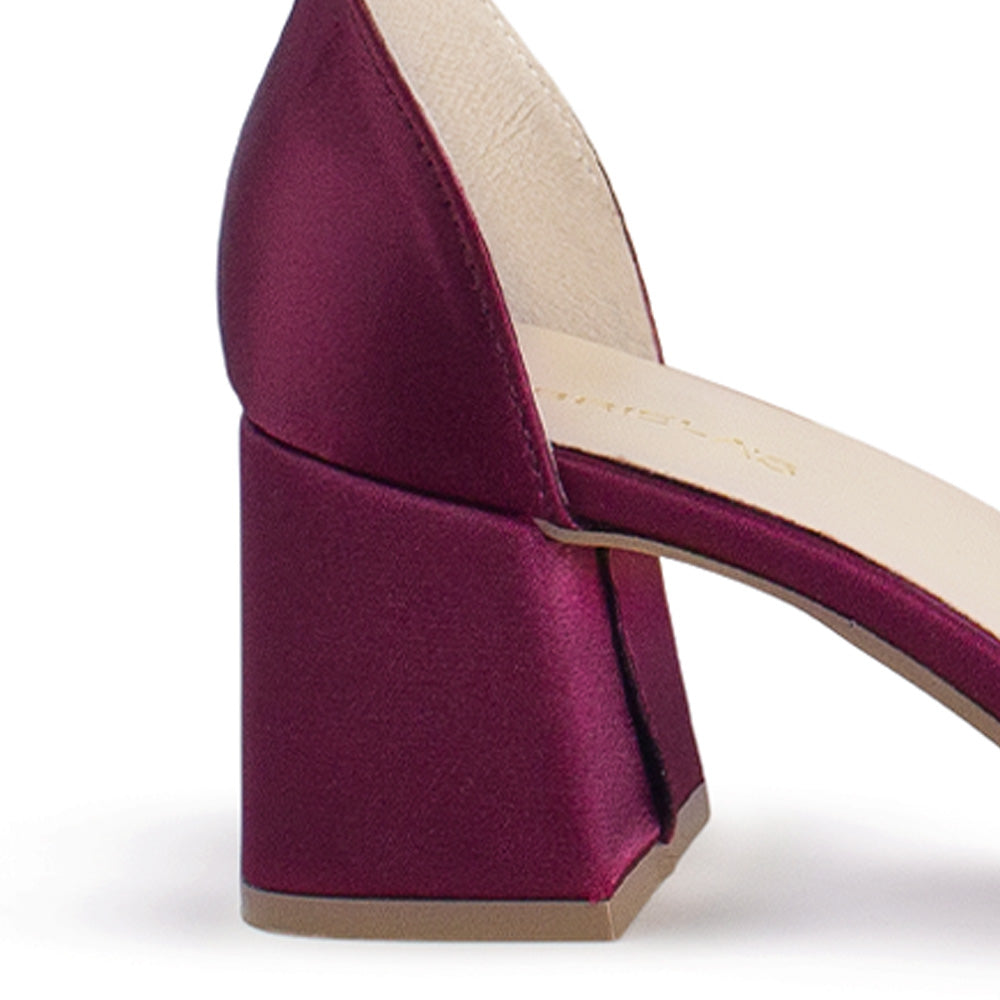 Vista trasera de tacón ancho medio de 7cm en zapatilla vino con pulsera ajustable al tobillo y pedrería en banda cruzada