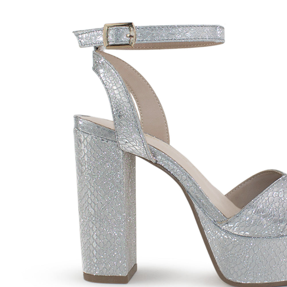 Vista trasera del tacón alto 12cm de la zapatilla plateada con plataforma, pulsera ajustable y tiras cruzadas para dama 