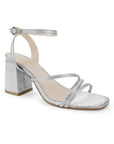 Vista diagonal de la zapatilla plateada para fiesta con tacón medio 7cm, pulsera ajustable al tobillo y tiras delgadas para dama 