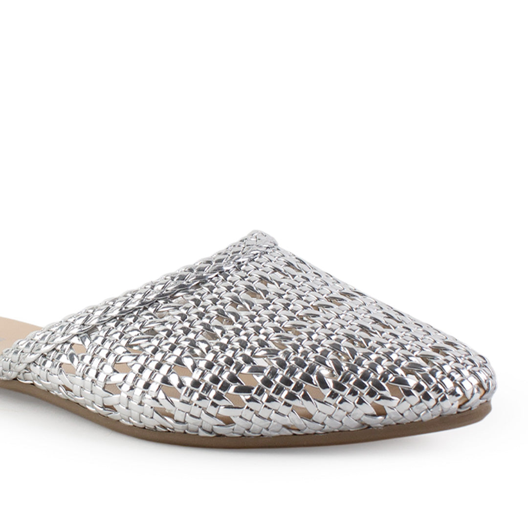 Vista a detalle de diseño trenzado perforado en flats tipo mules plateados para mujer de piso 