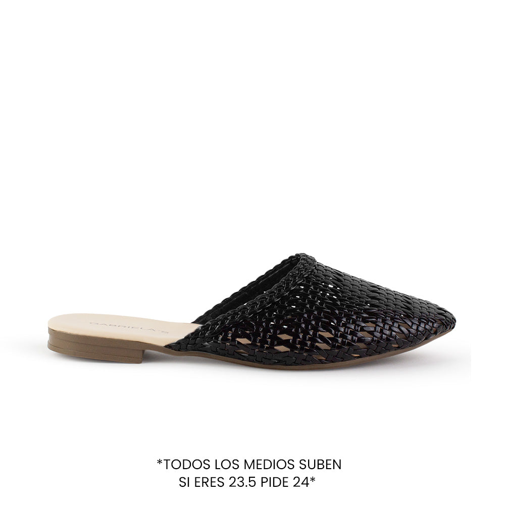 Vista lateral de flats tipo mules negros perforados para mujer con punta fina calada de meter 