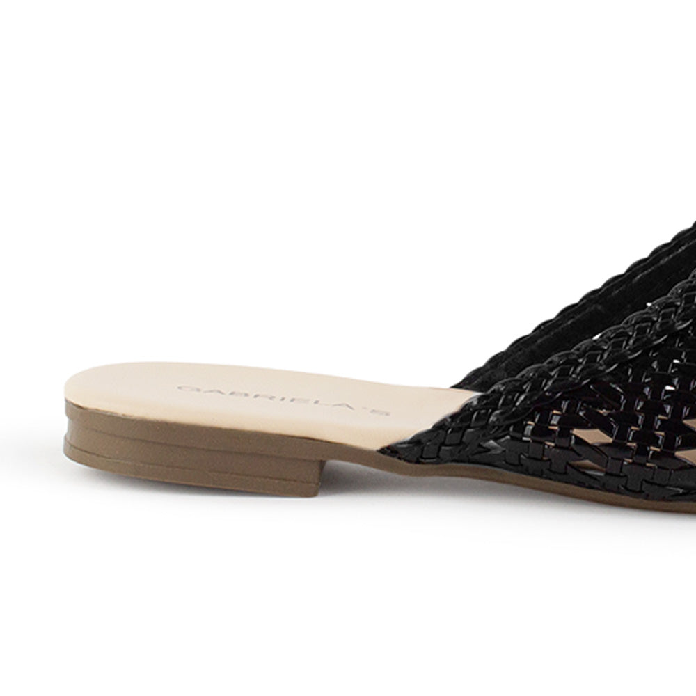 Vista trasera de flats tipo mules negros de piso para mujer de meter con punta calada de diseño trenzado 