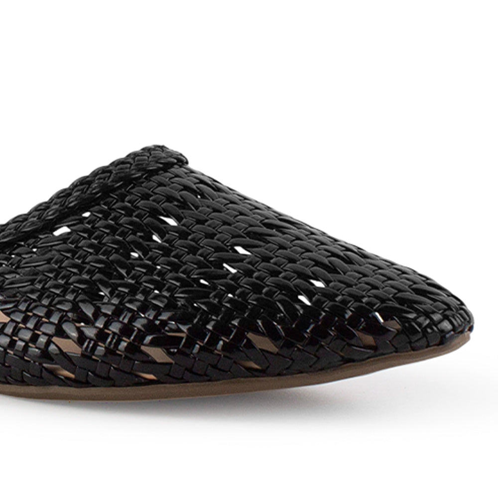 Vista a detalle de diseño trenzado perforado en flats tipo mules negros para mujer de piso 