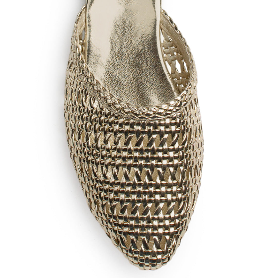 Vista de material sintético en flats dorados de piso para mujer con punta perforada fina tipo mules destalonadas