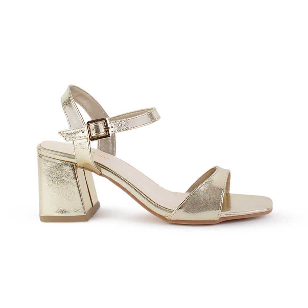 Vista lateral de zapatilla dorada para mujer con pulsera ajustable tira frontal y tacón grueso de 7cm
