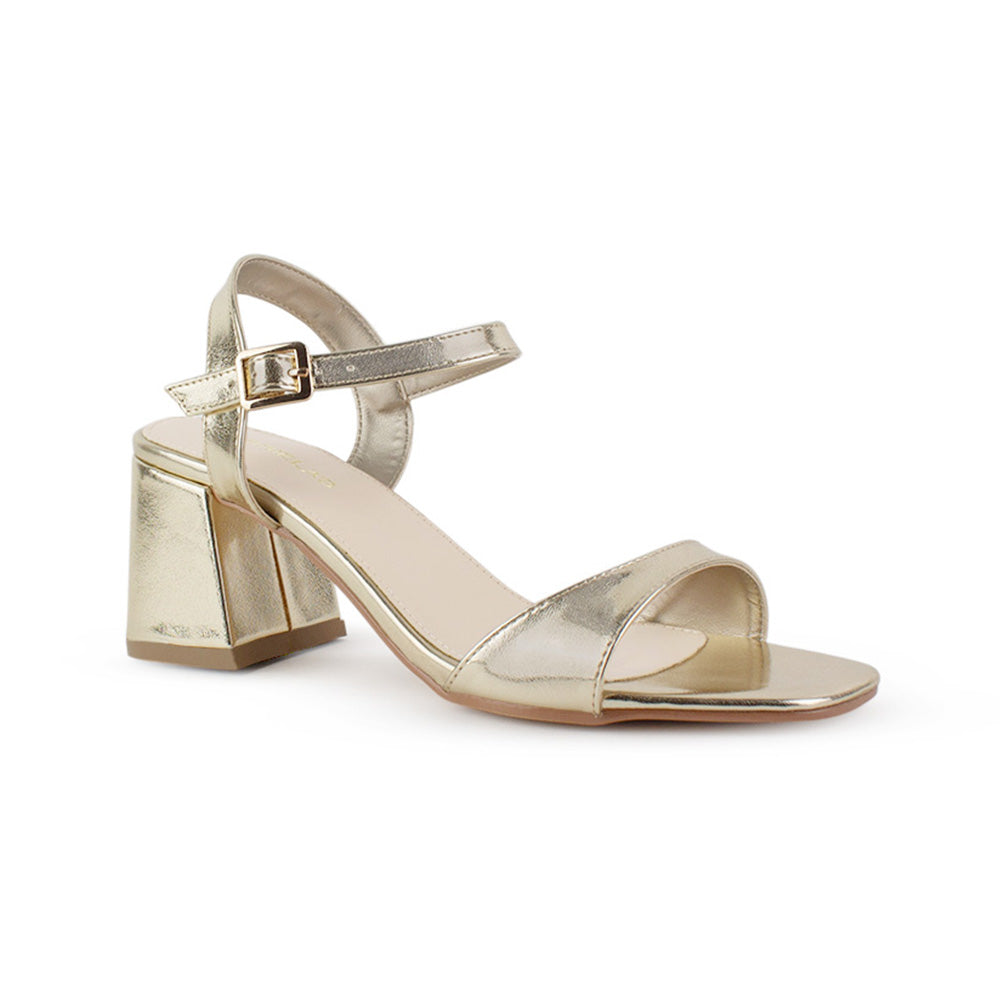Vista diagonal de zapatilla dorada de diseño descubierto para mujer con pulsera ajustable y tacón grueso de 7cm