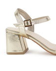 Vista trasera de tacón grueso medio de 7cm en zapatilla dorada para mujer con pulsera ajustable 