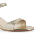 Vista a detalle de zapatilla dorada para mujer de diseño descubierto con pulsera ajustable con tira al frente