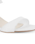 Vista a detalle de zapatilla blanca para mujer de diseño descubierto con pulsera ajustable con tira al frente