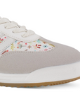 Detalle del material sintético en tenis beige con punta gris de diseño floral y suela baja 2cm para dama 