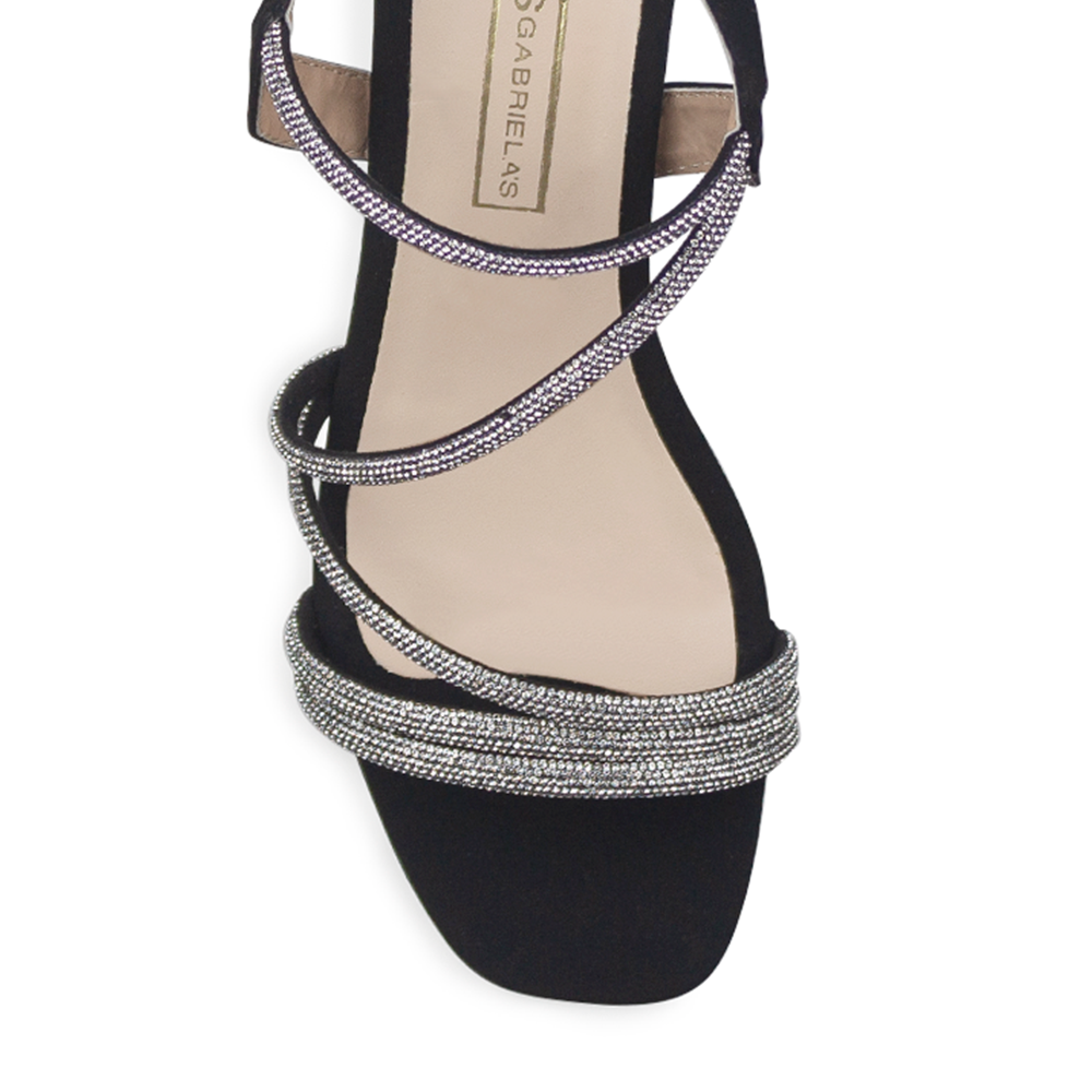 Vista de material buck en zapatilla para mujer con tiras de pedrería brillante en color negro