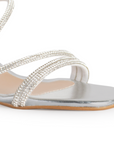 Vista a detalle de zapatilla plata para mujer con tiras brillantes y tacón bajo de 6cm