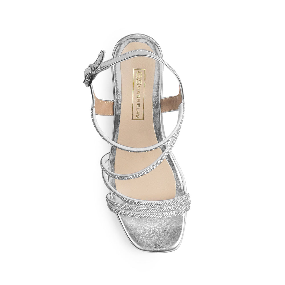 Vista superior de zapatilla plateada con punta cuadrada de diseño descubierto tiras forradas de pedrería y pulsera ajustable 