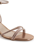 Vista a detalle de diseño descubierto con tiras de pedrería en zapatilla oro rosa para mujer con tacón bajo de 6cm
