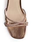 Vista de material sintético en zapatilla de diseño descubierto para mujer con tiras cruzadas con pedrería pulsera al tobillo ajustable y tacón bajo de 6cm en color oro rosa