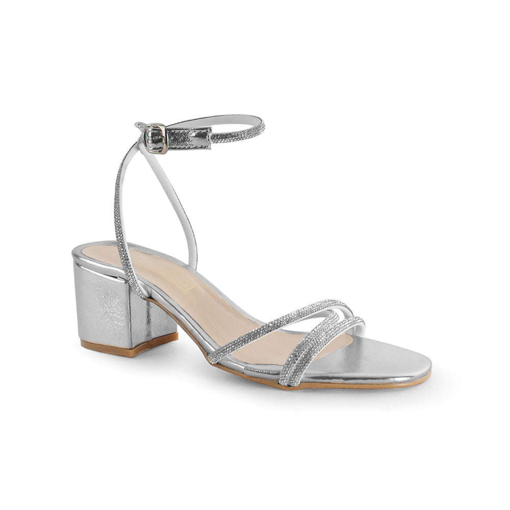 Vista diagonal de zapatilla plateada de diseño descubierto para mujer con tiras de pedrería pulsera al tobillo y tacón bajo de 6cm