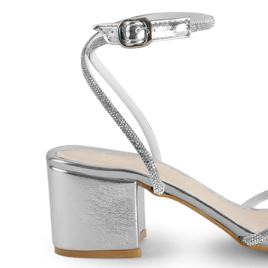 Vista trasera de tacón bajo ancho de 6cm en zapatilla plateada para mujer con pulsera al tobillo 