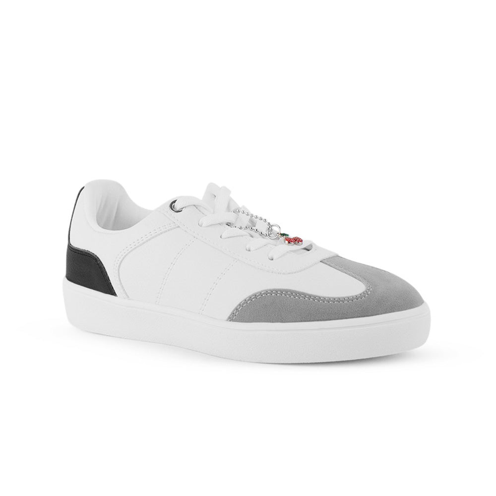 Vista diagonal de tenis blanco con negro para mujer con colgante en agujetas y suela baja de punta redonda