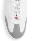 Vista de material sintético en tenis blanco con negro para mujer con punta redonda, suela baja y adorno colgante 