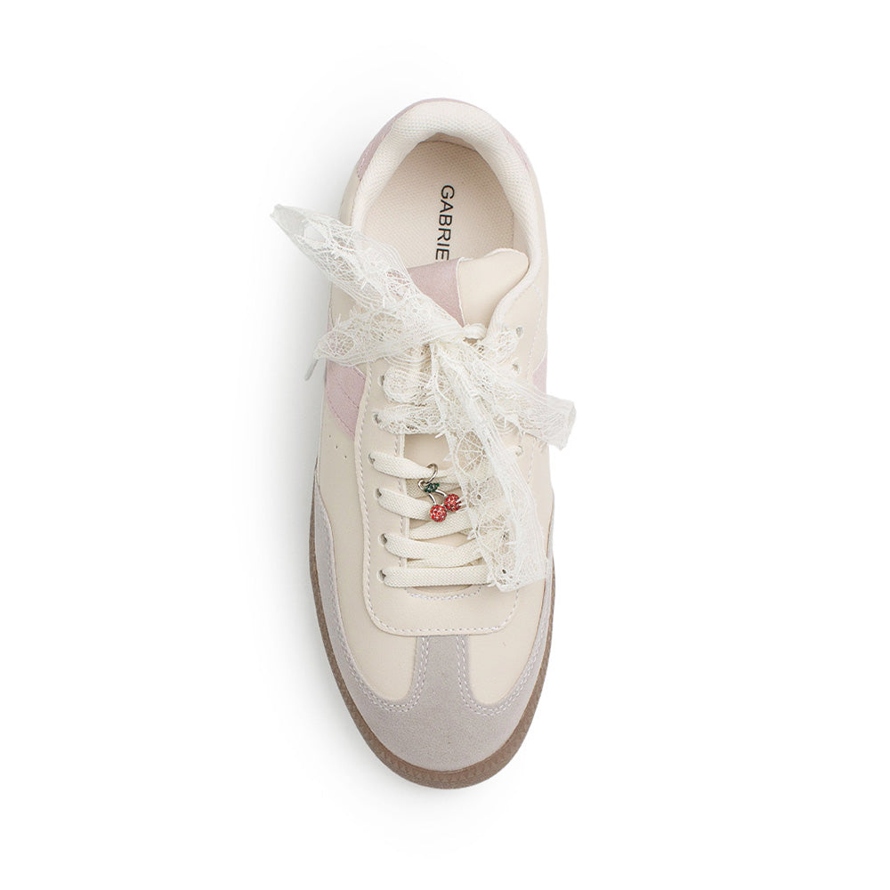 Vista superior de tenis beige con rosa de punta redonda para mujer con adorno colgante en las agujetas 