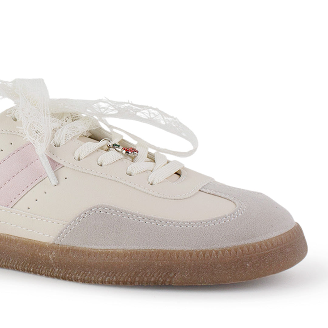 Vista de punta redonda en tenis beige con rosa para mujer con colgante en agujetas y suela baja