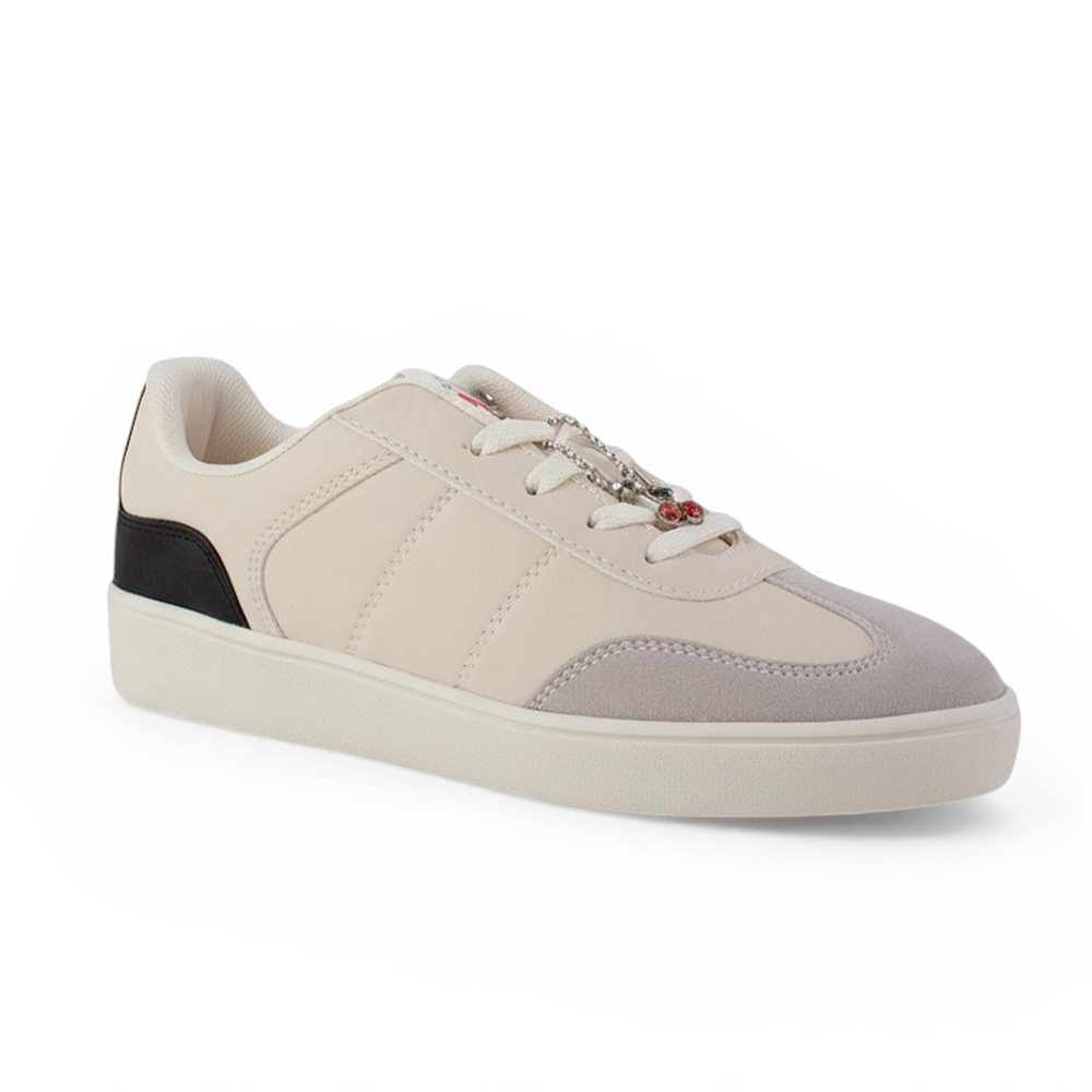 Vista diagonal de tenis beige con negro para mujer con colgante en agujetas y suela baja de punta redonda