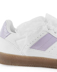 Vista trasera de suela baja en tenis blanco con morado para mujer con ajuste de agujetas y colgante 