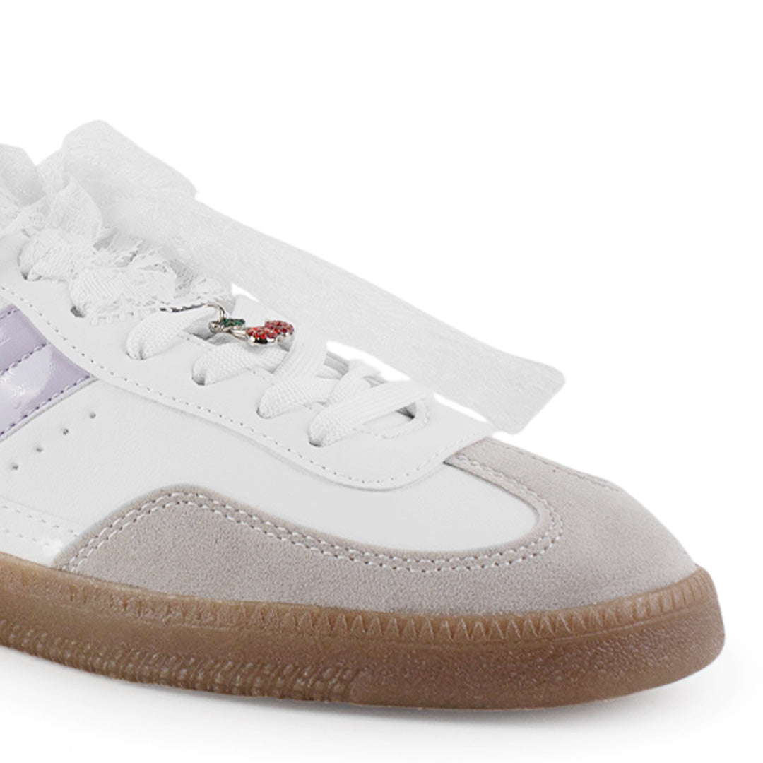 Vista de punta redonda en tenis blanco con morado para mujer con colgante en agujetas y suela baja