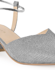 Vista a detalle de correa ajustable en zapatilla plata para mujer con tacón bajo de 5cm