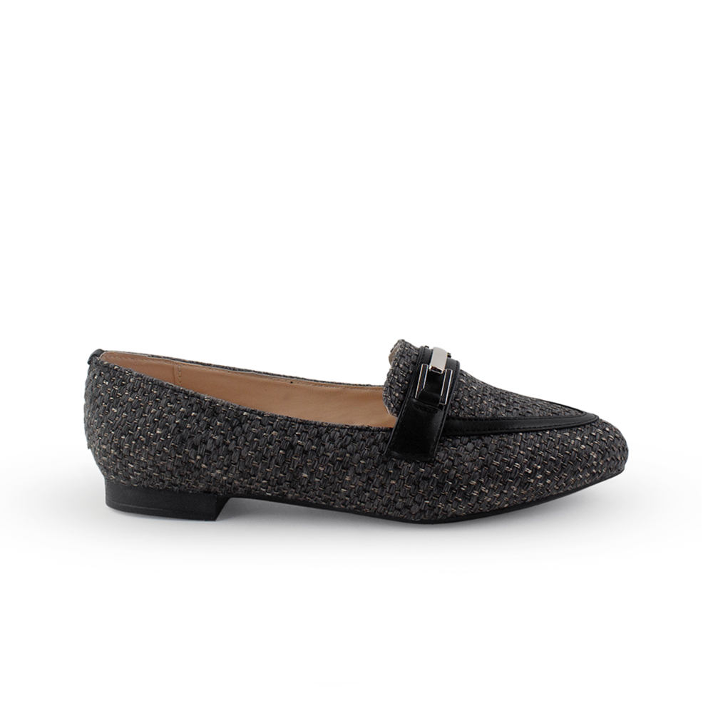 Vista lateral de mocasín negro para mujer con herraje decorativo y punta fina de piso