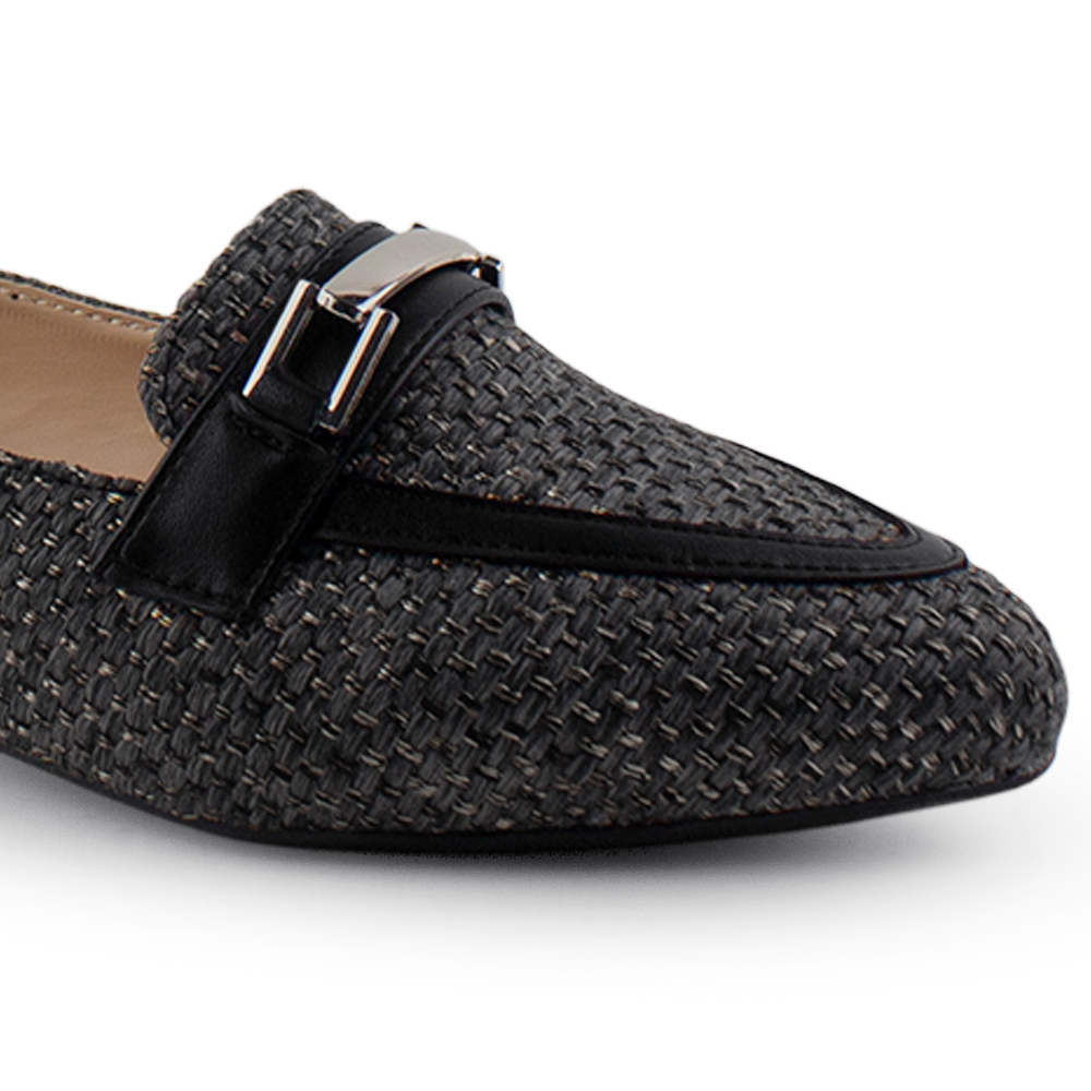 Vista a detalle de punta fina en mocasín negro para mujer con herraje decorativo de piso 