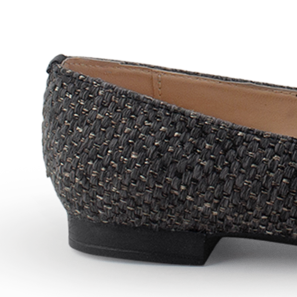 Vista trasera de mocasín negro de piso para mujer con herraje decorativo y punta fina 