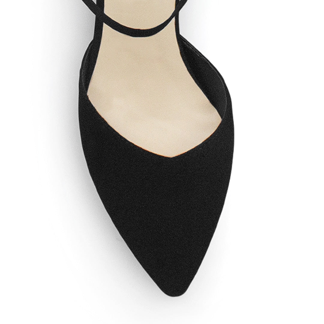 Vista de material buck en zapatilla para mujer con correa ajustable y tacón bajo de 5cm en color negro 