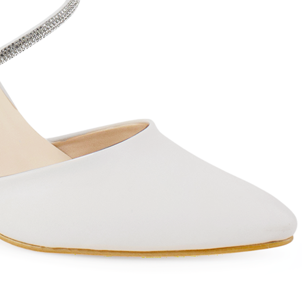 detalle del material cabra sintético en zapatillas beige para dama con punta fina y tiras con pedrería 