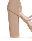 Vista trasera del tacón medio 10 cm en las zapatillas nude para dama con tiras cruzadas de pedrería y pulsera ajustable al tobillo 