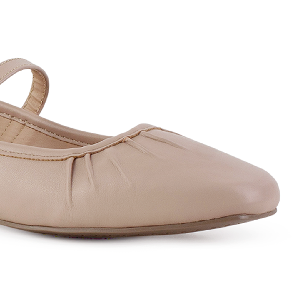 Detalle del material sintético en flats tipo balerinas nude para dama con pulsera ajustable y pliegues de piso 